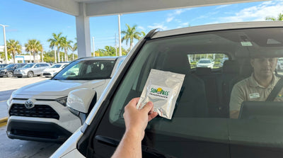 A SunPass transponder and shield bag on the dashboard of a car rental in Florida