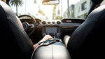 Close up of a phone plugged into a dashboard USB charging port inside a car rental in Los Angeles