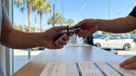 Close-up of a person holding a key fob at an Orlando car hire counter
