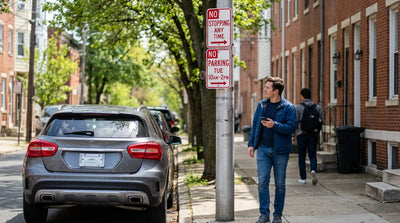 A tow truck prepares to remove an illegally parked car rental on a city street in Philadelphia, Pennsylvania