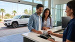 Close-up of a person handing a credit card to an agent at a car rental desk in Texas