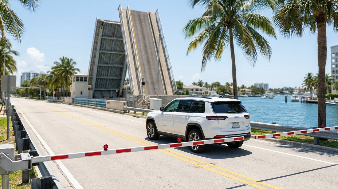 A car rental waits at the lowered barrier of a raised drawbridge in downtown Miami