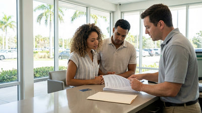 A red convertible car hire driving along a coastal road lined with palm trees in sunny Florida