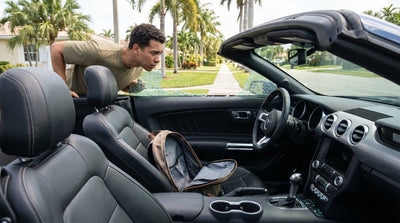 A white sedan car rental parked beside a sunny Florida beach with gentle ocean waves