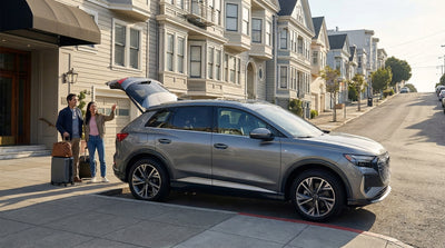 A person with luggage stands by their car hire parked on a steep San Francisco residential street