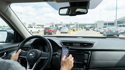 A driver in their car hire navigates the busy pickup lanes outside the JFK airport terminal in New York