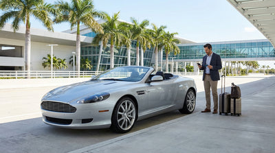 A premium convertible car rental parked on a sunny, palm-lined street in Miami
