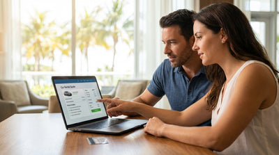 A white convertible car rental driving along a coastal highway in Florida with palm trees and blue ocean