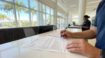 A person sitting in a modern car rental in Florida, carefully reading over the contract paperwork