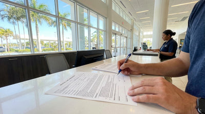 A person sitting in a modern car rental in Florida, carefully reading over the contract paperwork