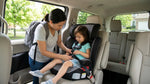 Toddler safely secured in a child seat in the back of a car rental driving past a scenic Pennsylvania landscape