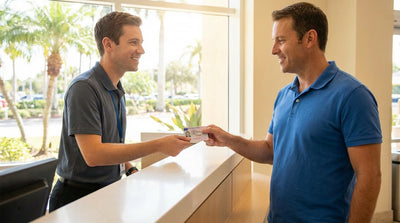 A red convertible car hire driving on a scenic coastal road lined with palm trees in sunny Florida