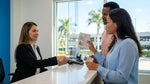 Man handing a driver license and passport to an agent at a car rental desk in Florida