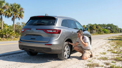 A car hire vehicle with a flat tire on the side of a sunny highway in Florida