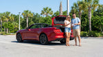 A modern sedan for car hire parked on a sunny street lined with palm trees in Orlando