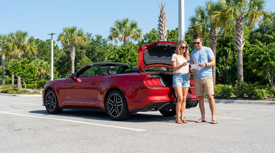 A modern sedan for car hire parked on a sunny street lined with palm trees in Orlando