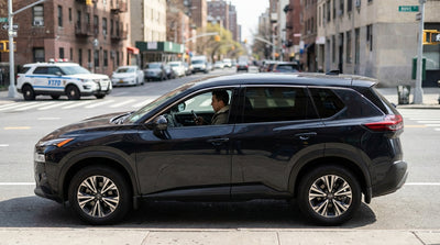 A New York police car with flashing lights stopped behind a black car hire with dark tinted windows