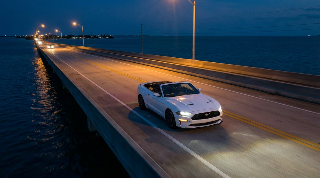 A car hire from Miami drives over a long ocean bridge in the Florida Keys during a dramatic sunset
