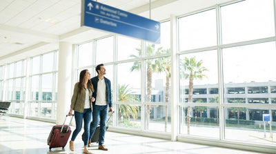 Travelers with luggage walk through the Orlando Airport on their way to the car rental desks