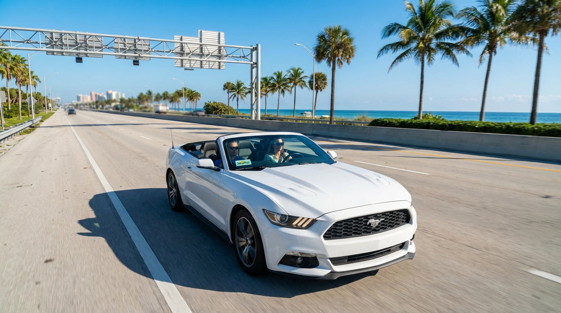 A white convertible car hire driving along Ocean Drive in Miami with palm trees and Art Deco hotels