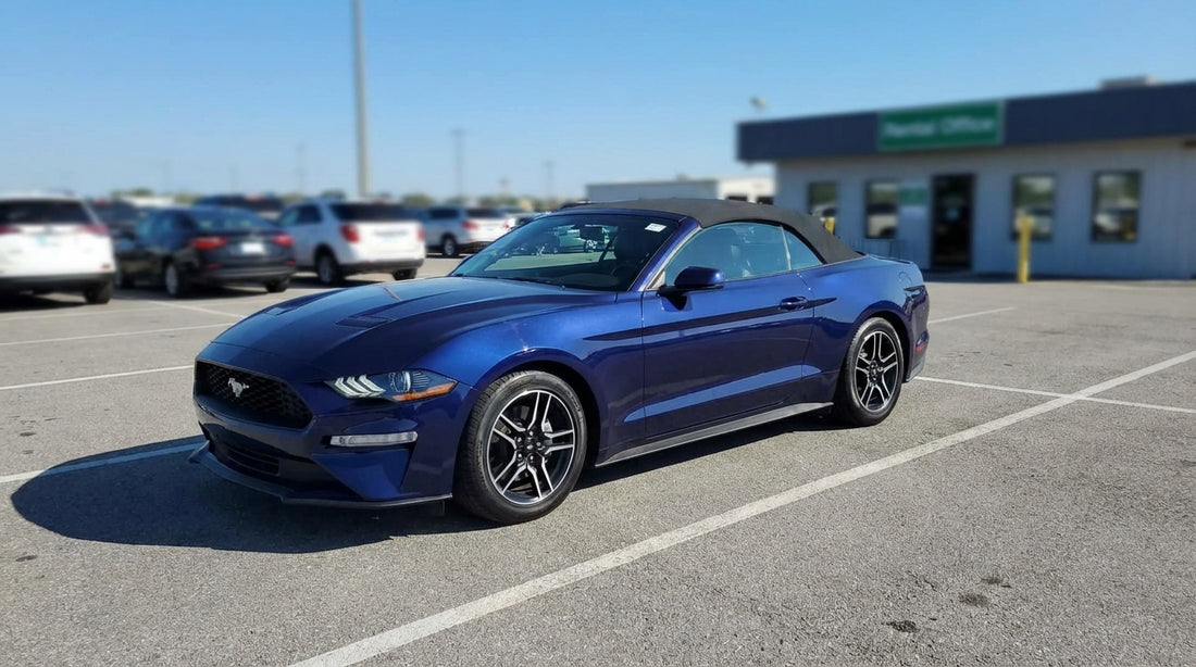 A red convertible car hire driving on a long desert highway towards the rock formations of Monument Valley, USA