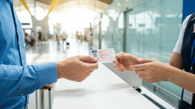 A red convertible car hire driving along a sunny coastal highway in California with the ocean to the side