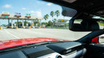 Dashboard view from a car rental driving under a toll gantry on a sunny Florida highway
