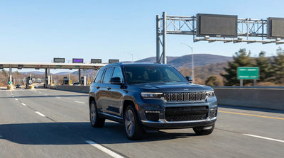A modern car hire driving on a highway surrounded by the green, rolling hills of rural Pennsylvania