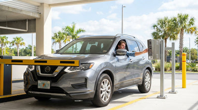 A driver in a car rental looks at a closed parking garage barrier at a theme park in Orlando
