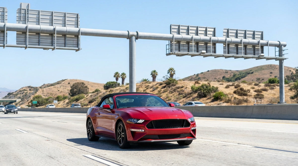 A white car rental driving on a scenic highway along the sunny California coast