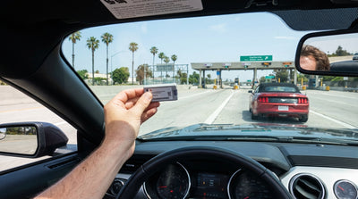 A red convertible car hire driving across the Golden Gate Bridge in California under a sunny sky
