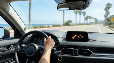 Close-up of a dashboard warning light illuminated in a car hire on a sunny California road