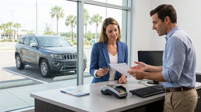 A person at a counter handing a credit card to an agent to complete their car hire in the United Estates