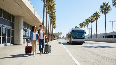 A traveler with luggage waits for the car rental shuttle outside the Burbank Airport terminal in Los Angeles