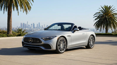 A luxury Mercedes-Benz car rental parked on a hill overlooking the sunny Los Angeles skyline and palm trees