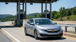 E-ZPass transponder on the windshield of a car rental driving through the Pennsylvania countryside