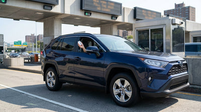 A modern car hire driving through an E-ZPass toll gantry on a highway in New York