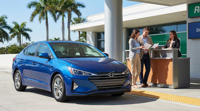 A red convertible car hire driving on a sunny coastal highway in Florida