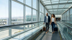 Passengers walking with suitcases through the San Francisco airport toward the car rental facility