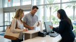 A customer at a car hire counter in Orlando discussing their rental agreement with an agent