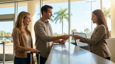 A white convertible car rental driving along a sunny, palm-lined coastal road in Florida