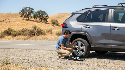 A car hire pulled over on the side of a sunny California highway with a flat tyre