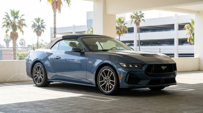 A convertible car hire on a sunny Los Angeles street lined with iconic tall palm trees