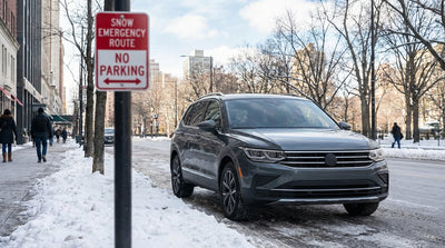 A car rental covered in snow parked on a quiet street in New York during a winter storm