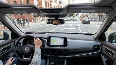 Driver's perspective from a car rental on a busy San Francisco street with mandatory turn-only lanes