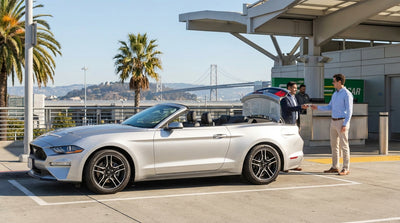 A red convertible car hire parked overlooking the Golden Gate Bridge in San Francisco on a clear day