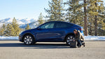 A car rental driving on a scenic, snow-lined mountain road through a forest in California