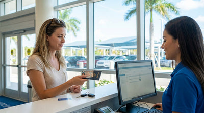 A person driving a convertible car hire down a sunny highway lined with palm trees in Florida