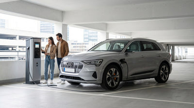 An electric car hire plugged into a charging station on a bustling New York City street