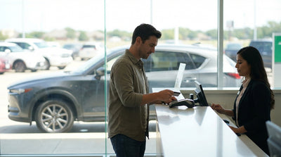 A modern sedan car rental parked on the side of a scenic highway in the Texas hill country